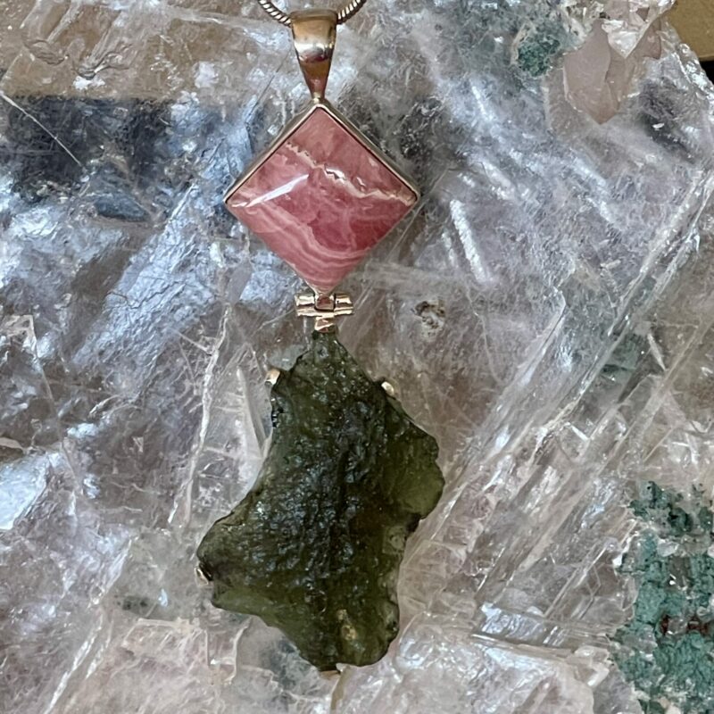 This is a stunning Moldavite and Rhodochrosite pendant hand crafted and set in stirling silver. thecrystalcave.com.au
