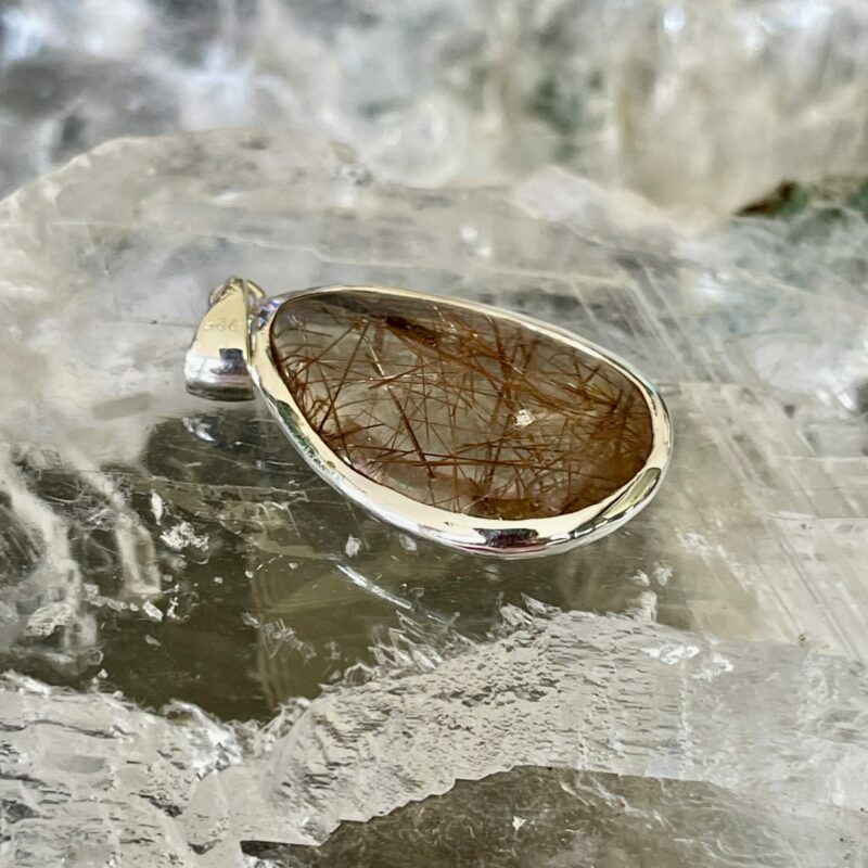 This is a beautiful Tear drop shaped golden rutile cabochon pendant. It is set in 925 silver. thecrystalcave.com.au