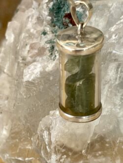 This is a clear cylinder filled with Moldavite set in 925 stirling silver. thecrystalcave.com.au