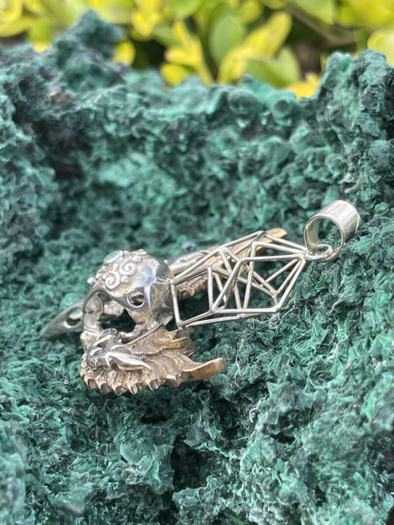 This is Brass and Silver Hypercube Raven Skull Wing Pendant