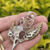 This is Brass and Silver Hypercube Raven Skull Wing Pendant