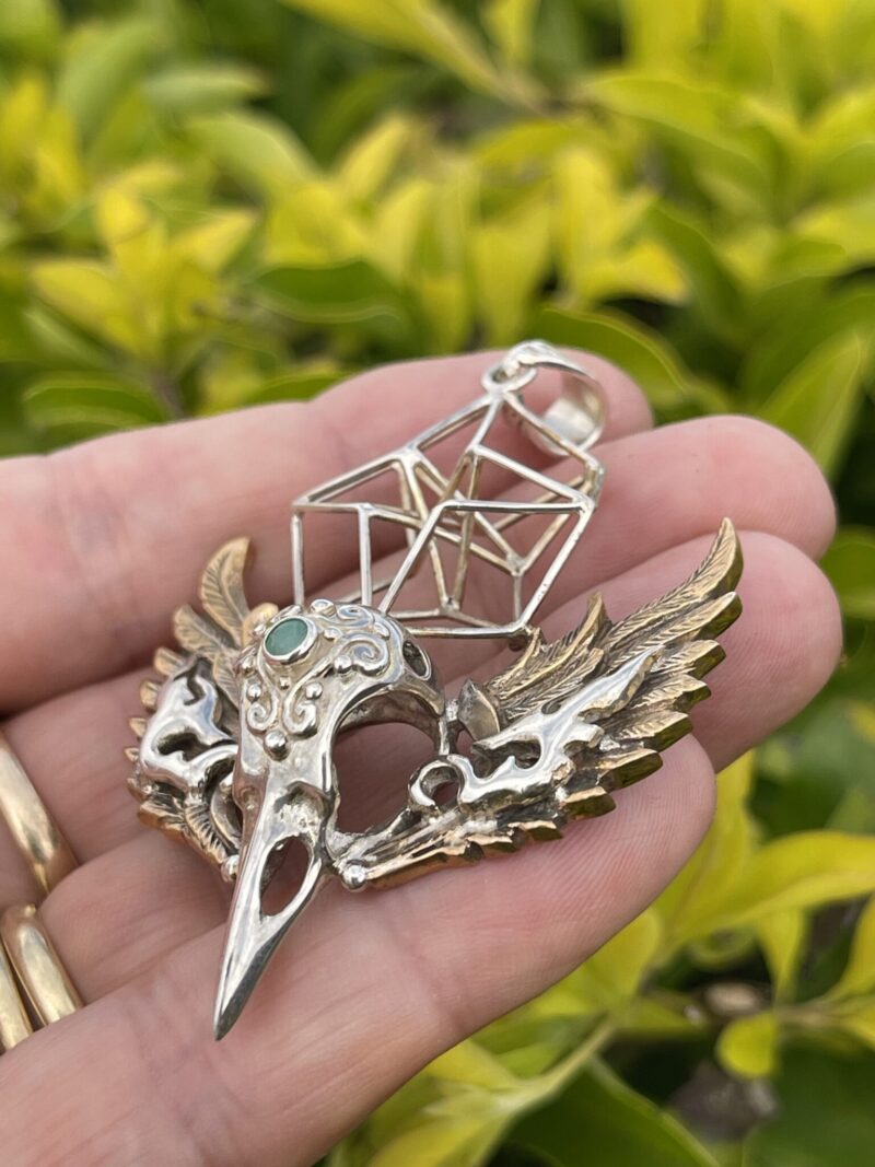 This is Brass and Silver Hypercube Raven Skull Wing Pendant