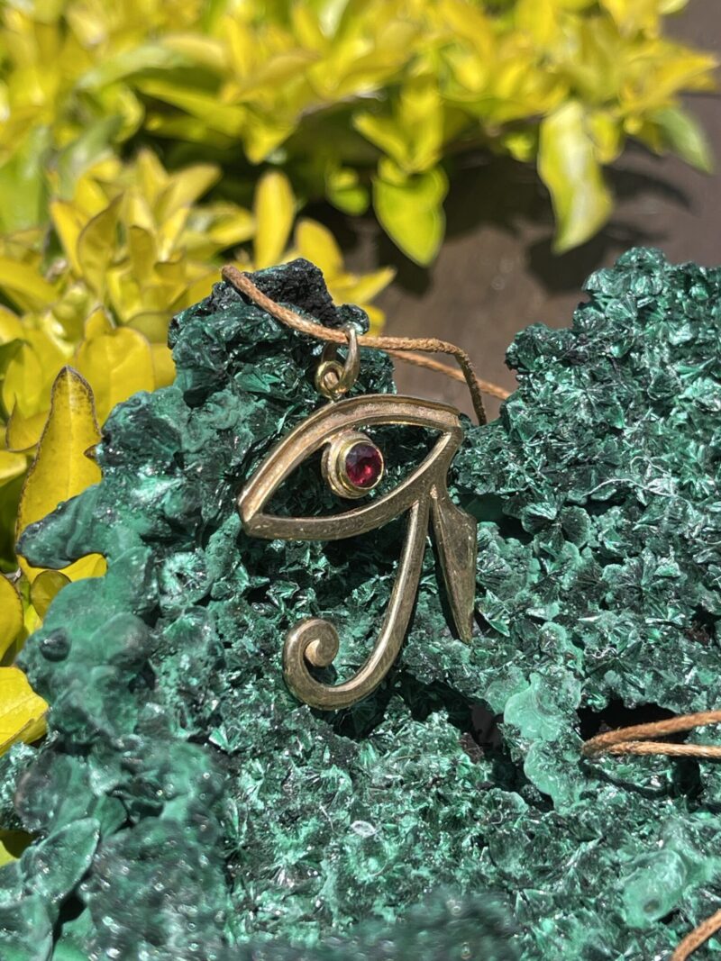 This is stunning Brass Eye of Horus Pendant with Garnet Eye